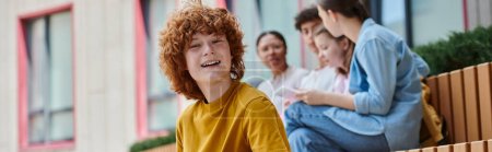 banner, happy redhead boy with curly hair looking at camera, blur, diversity, students and teacher