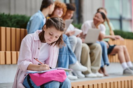 zurück in die Schule, Teenager-Mädchen macht sich Notizen in der Nähe von Klassenkameraden und Lehrern, Unschärfe, Diversität, Zuordnung