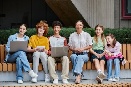 Photo for Back to school, teenagers with gadgets sitting with african american teacher, diversity, education - Royalty Free Image