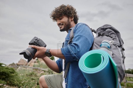 Reisefotografiekonzept, glücklicher indischer Backpacker mit Digitalkamera während der Reise
