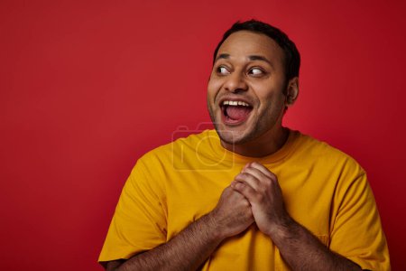Photo for Astonished indian man with wide eyes open looking away on red background in studio, surprise concept - Royalty Free Image