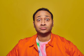 shocked indian man with eyes wide open looking at camera isolated on yellow, face expression puzzle #670406904
