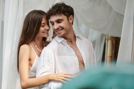 Téléchargez les photos : Couple heureux, homme et femme joyeux en vêtements blancs souriant pendant les vacances d'été - en image libre de droit