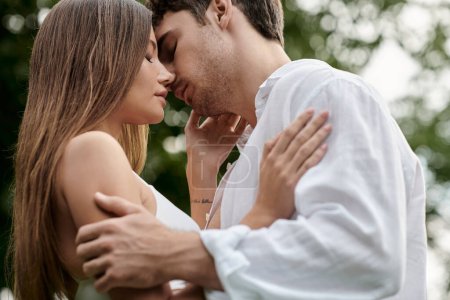 Foto de Vista lateral del hombre besando novia en la parte superior de la cosecha y de pie juntos al aire libre, pareja romántica - Imagen libre de derechos