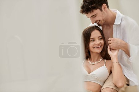 Photo for Happy man holding hands with pretty woman with tattoo, spending time together outdoors, looking away - Royalty Free Image