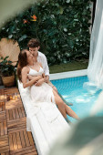 couple in white clothes sitting together near swimming pool during vacation, romantic getaway t-shirt #672029358