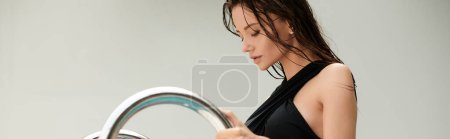 Téléchargez les photos : Séduisante femme aux cheveux mouillés debout en maillot de bain et tenant une main courante dans la piscine, bannière - en image libre de droit