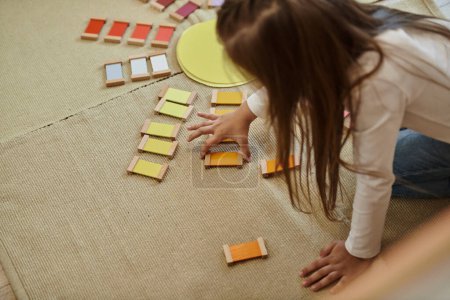 Montessori-Material, intelligentes Mädchen spielt pädagogisches Farbspiel in Form von Sonne, frühe Bildung
