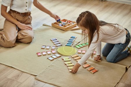 montessori school, girl near color educational game in shape of sun, teacher, early education
