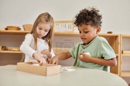 aprendizaje matemático, niño afroamericano jugando con chica, concepto de escuela montessori, diversos niños