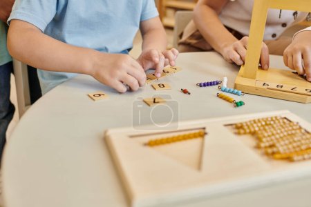 escuela montessori, vista recortada de los niños jugando juego educativo, aprendizaje matemático, juego educativo