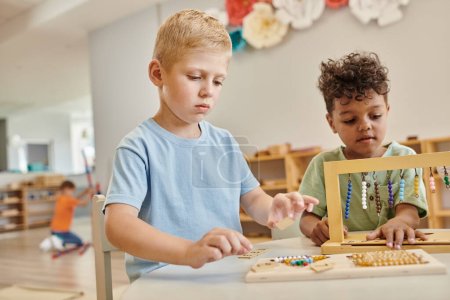 montessori school concept, multicultural boys playing with color bead stairs, learn through play