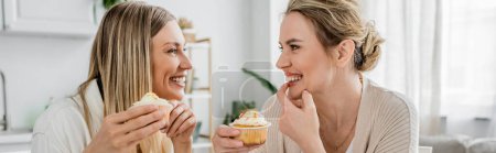 atractivas hermanas con clase en traje de pastel disfrutando de cupcakes en el fondo de la cocina, vinculación, pancarta