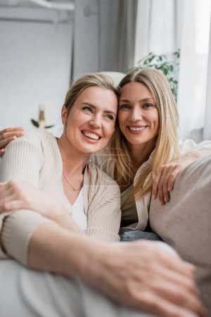 Photo for Close up of attractive sisters in casual clothing smiling and hugging warmly, family bonding - Royalty Free Image