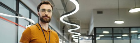 Téléchargez les photos : Entrepreneur à barbe réussie dans les lunettes de vue regardant la caméra dans l'espace de bureau - en image libre de droit