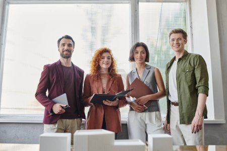 professional headshot of creative architects near building model in modern office