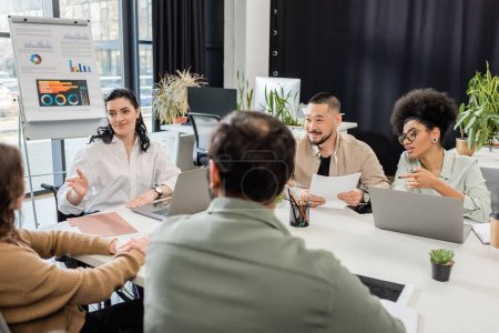 glückliche multikulturelle Geschäftsleute diskutieren Projekt und Brainstorming über modernes Coworking Office