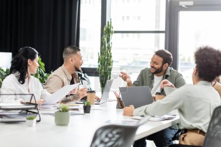 glückliche Teamleiter diskutieren Projekt mit interracial Startup-Team in Coworking, Geschäftsleute