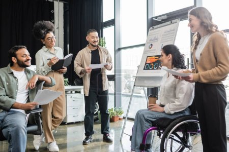 concept d'inclusion, femme en fauteuil roulant travaillant ensemble dans les hommes d'affaires interraciaux au bureau