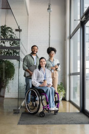 foto grupal de gente de negocios diversa e inclusiva mirando a la cámara, usuario de silla de ruedas en la oficina