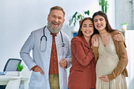 cheerful lgbt couple expecting their baby standing near their grey bearded doctor, ivf concept