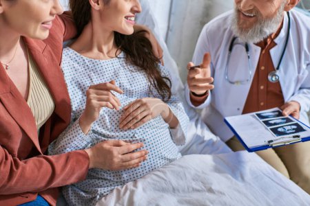 recortado vista de lesbianas pareja sonriendo mientras médico mostrando ellos ultrasonido de bebé, ivf concepto