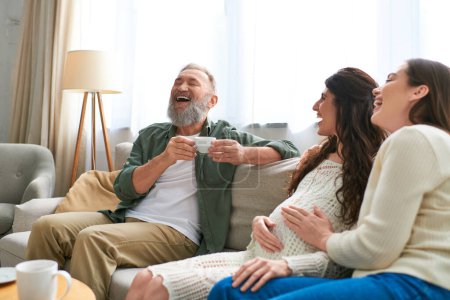 cheerful father laughing with his daughter and her partner while drinking coffee, ivf concept