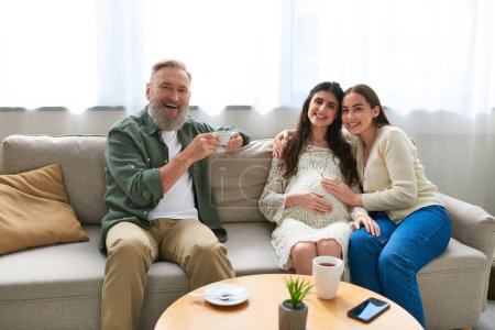 happy lgbt family and father of one of them drinking coffee and smiling at camera, ivf concept