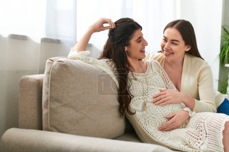 alegre espera pareja sentado en sofá sonriendo calurosamente el uno al otro, in vitro concepto de fertilización