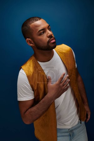 handsome african american man with beard looking away with hand on his chest, fashion concept