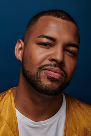 handsome african american man looking at camera and slightly smiling at camera, fashion concept