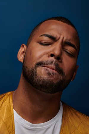 portrait of contented handsome african american man with beard closing his eyes, fashion concept