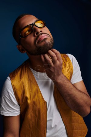 handsome man in sunglasses with beard scratching his chin and looking away, fashion concept