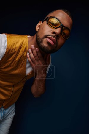 Photo for Stylish man in sunglasses smiling slightly looking at camera, hand on neck, fashion concept - Royalty Free Image
