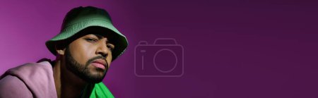 Photo for Stylish male model in trendy green panama looking suspiciously at camera, fashion concept, banner - Royalty Free Image