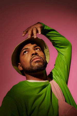 Téléchargez les photos : Bel homme afro-américain avec des bagues en argent en panama vert geste, concept de mode - en image libre de droit