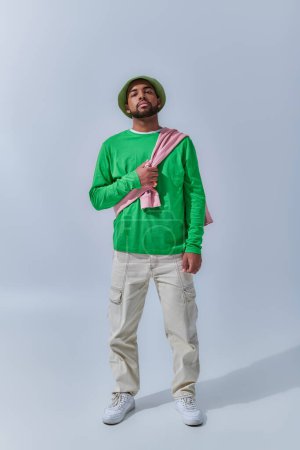 junge trendige männliche Modell in Freizeitkleidung mit Sweatshirt auf den Schultern gebunden, Modekonzept