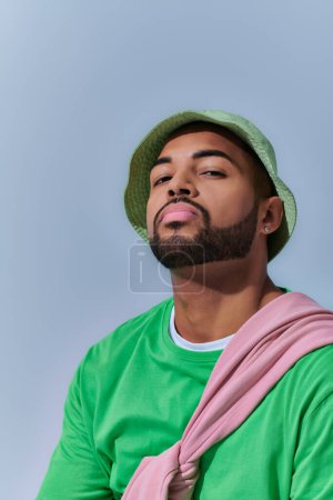 portrait of bearded stylish man with diamond earring in panama looking at camera, fashion concept