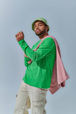 dynamisches Foto von jungen afrikanisch-amerikanischen Mann mit Sweatshirt auf den Schultern gebunden, Modekonzept