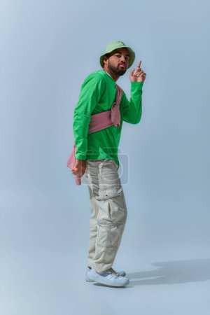 schöner afrikanisch-amerikanischer Mann bewegt sich und zeigt mit erhobenem Zeigefinger in die Kamera, Modekonzept