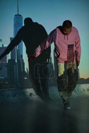good looking african american man with beard in pink hoodie waking looking down, fashion concept
