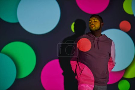 Photo for Handsome man with hands behind back and closed eyes in digital projector lights, fashion concept - Royalty Free Image