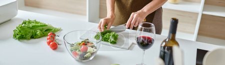 pancarta recortada de la mujer cortando lechuga fresca y haciendo ensalada de verduras cerca del vaso de vino tinto