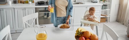 child playing with wooden tongs near mom with delicious croissant and fresh orange juice, banner