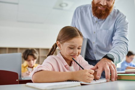 A kind man, acting as a teacher, is helping a young girl with her homework in a bright and lively classroom setting.