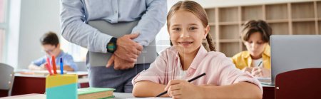 Photo for A young girl is attentively seated at a desk in a classroom, fully engrossed in study - Royalty Free Image