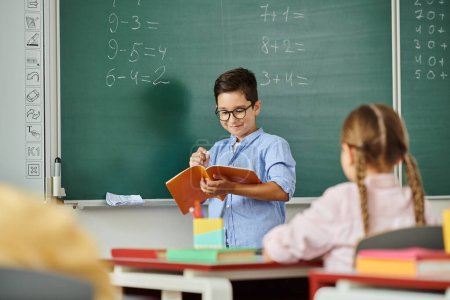 Ein Junge und ein Mädchen sitzen aufmerksam vor einer Tafel und saugen Wissen in einem lebendigen Klassenzimmer auf..