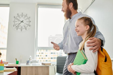 Photo for A man and a little girl standing in front of a whiteboard in a bright, lively classroom setting - Royalty Free Image