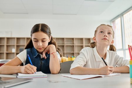 Zwei junge Mädchen nehmen aktiv an einem Klassenzimmer teil