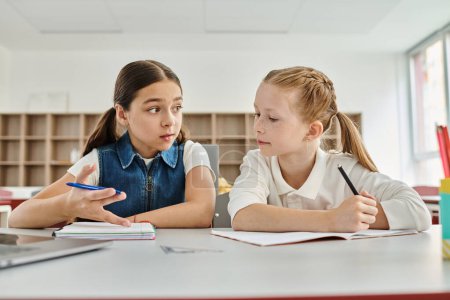 Photo for Two young girls attentively listen and engage in a classroom lesson, soaking in knowledge and inspiration. - Royalty Free Image